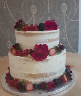 Fruchtig gefüllte Cremetorte mit Blumen und Beeren